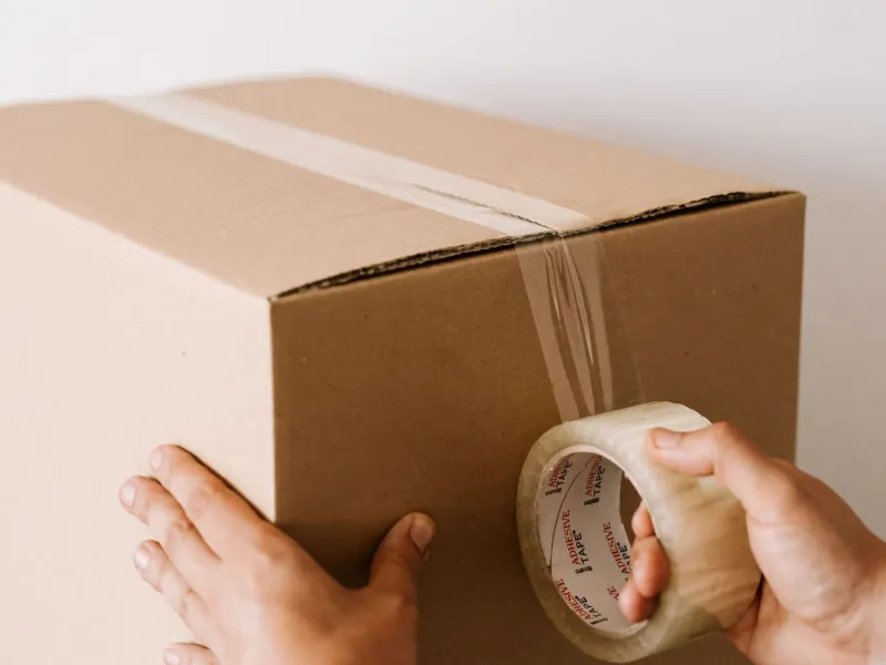 Packer sealing a carton box for packing services in Kakinada