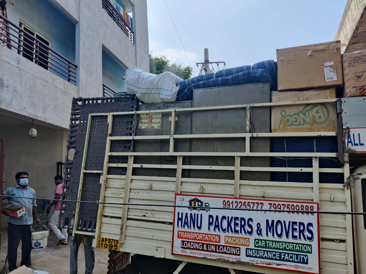 Household goods being loaded into a Hanu Packers and Movers truck in Kakinada